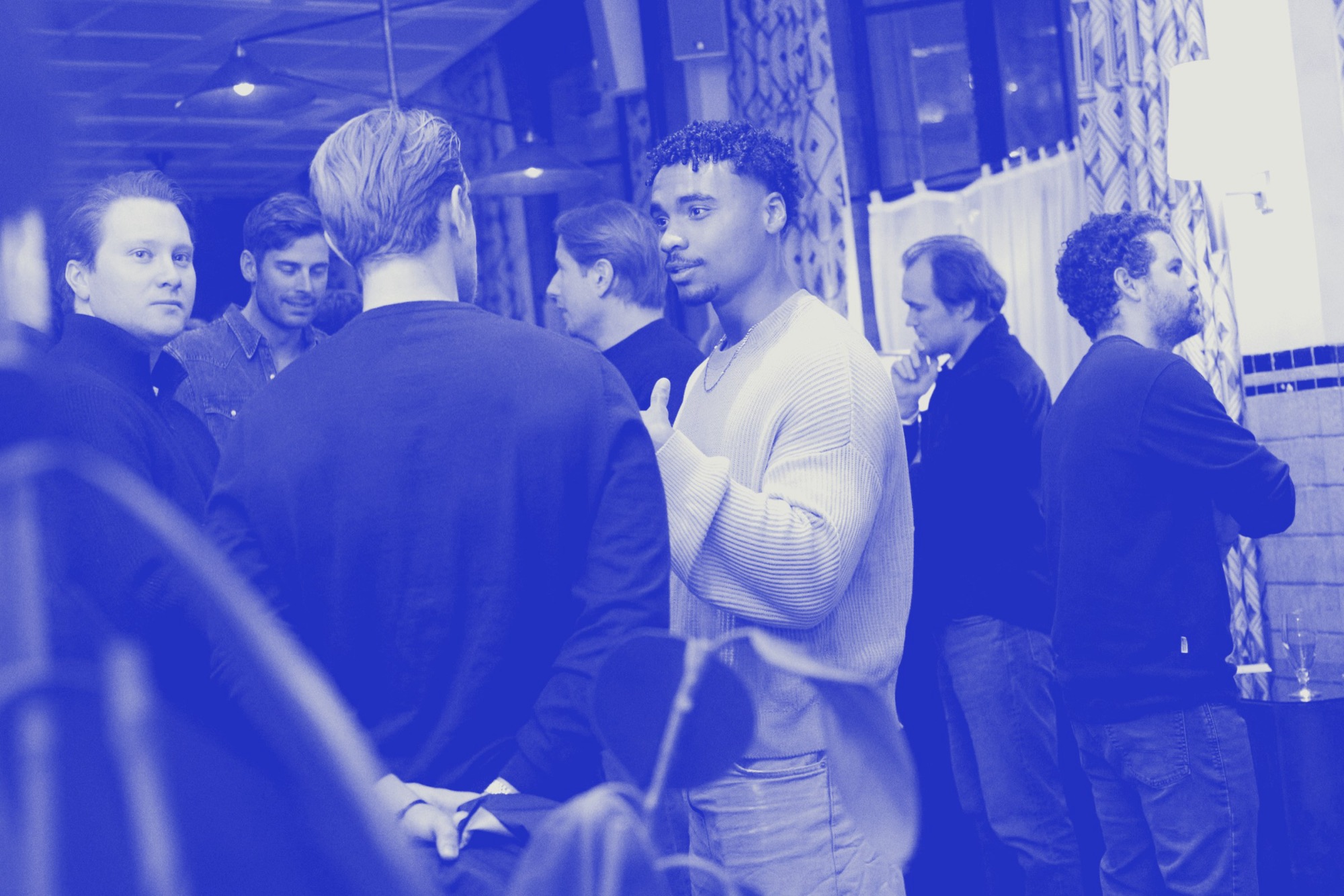 Founders talking in a standing group, in ultramarine duotone